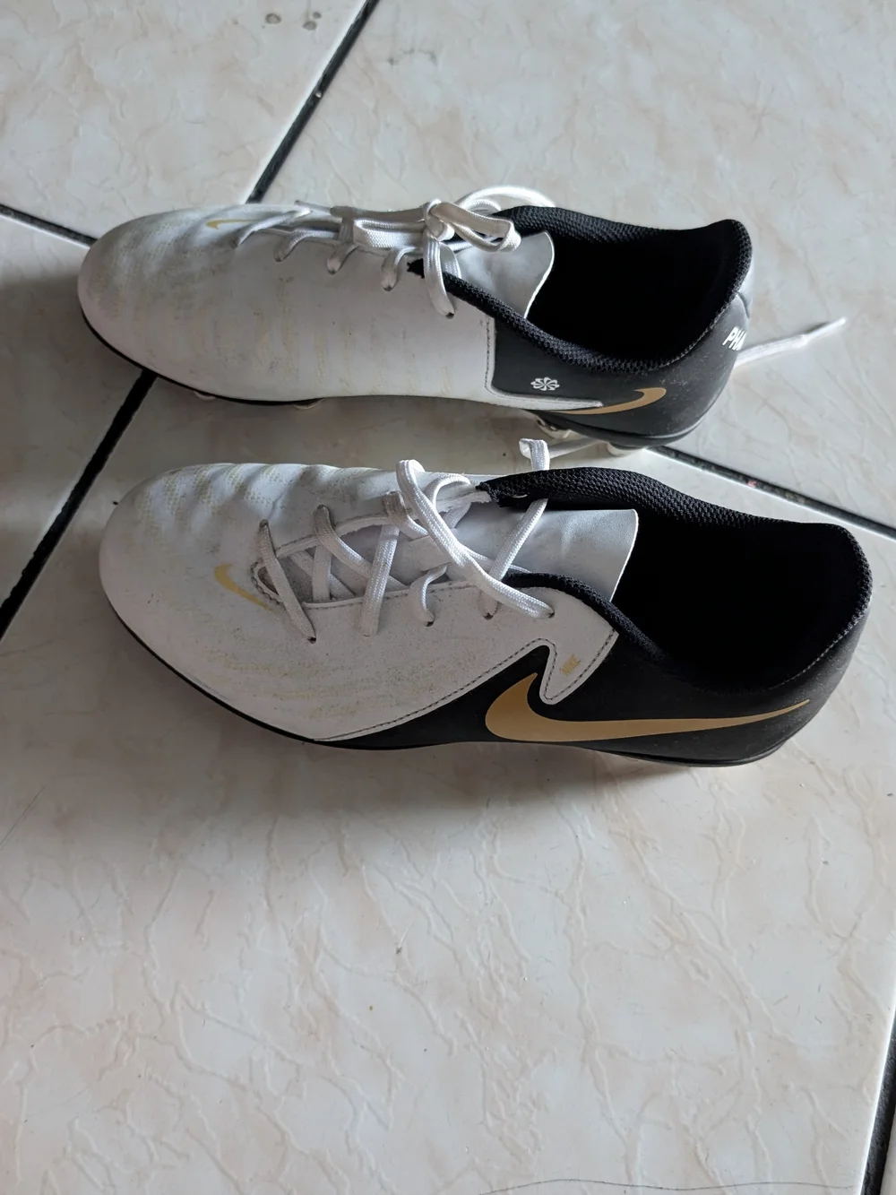 Nike White and Black Soccer Cleats with Gold Swoosh